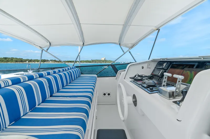 Crown Jewel Yacht Photos Pics Broward 96 Raised Pilothouse MY 1996 yacht helm with striped seating, ocean view.