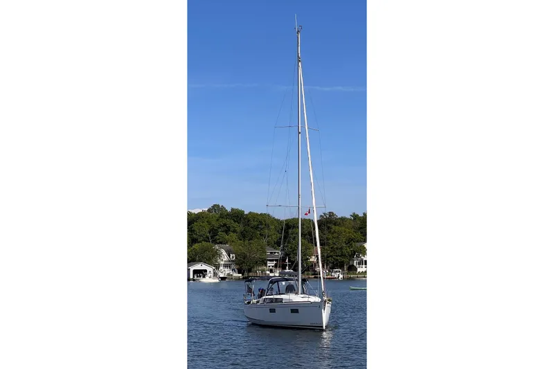  Yacht Photos Pics Beneteau Oceanis 38.1 sailboat, 2021 model, on a serene lake with clear blue sky.