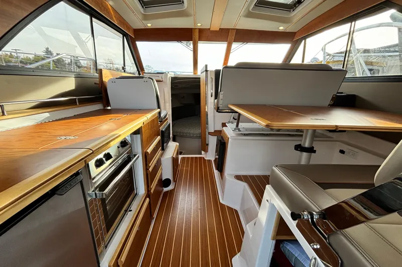  Yacht Photos Pics 2022 Cutwater C-32 CB interior with wood finish, kitchen, and seating area.
