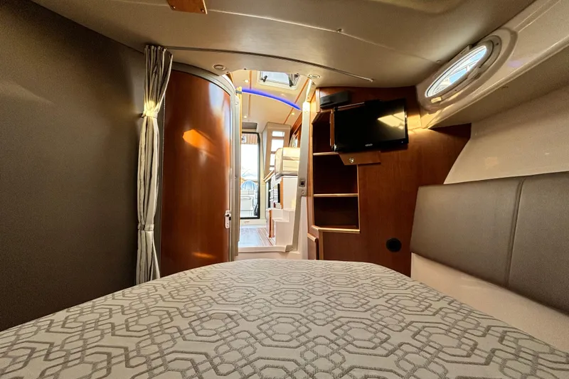  Yacht Photos Pics Interior of 2022 Cutwater C-32 CB boat, featuring cozy cabin with bed, TV, and wooden accents.