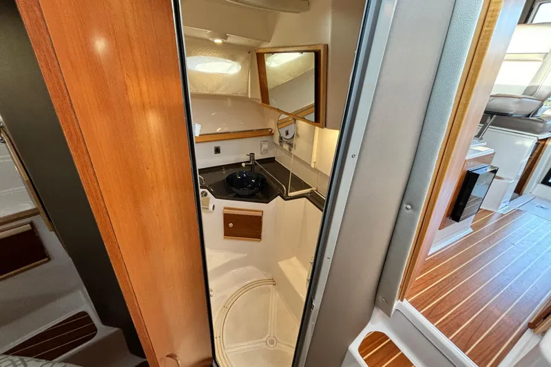  Yacht Photos Pics 2022 Cutwater C-32 CB boat interior with modern bathroom and wooden flooring.
