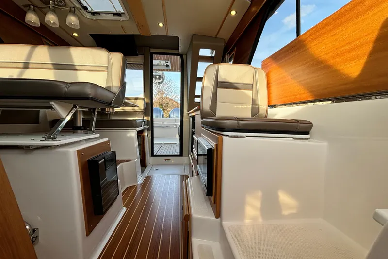  Yacht Photos Pics Interior of 2022 Cutwater C-32 CB boat with modern seating and wood accents.