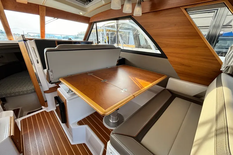  Yacht Photos Pics 2022 Cutwater C-32 CB interior with wood accents and convertible dining area.