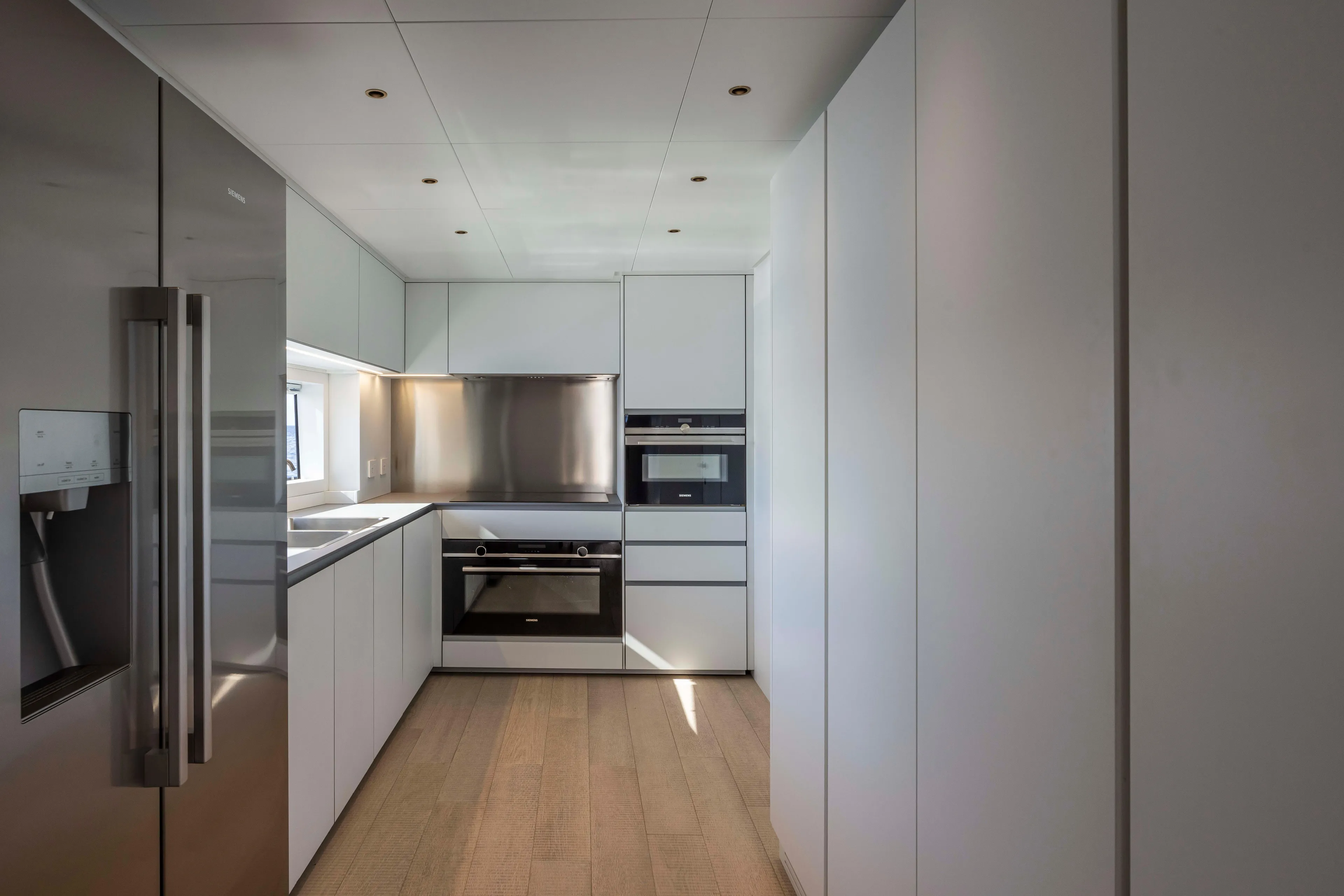  Yacht Photos Pics Modern kitchen interior on 2024 Arcadia Yachts A96, featuring sleek cabinetry and stainless steel appliances.