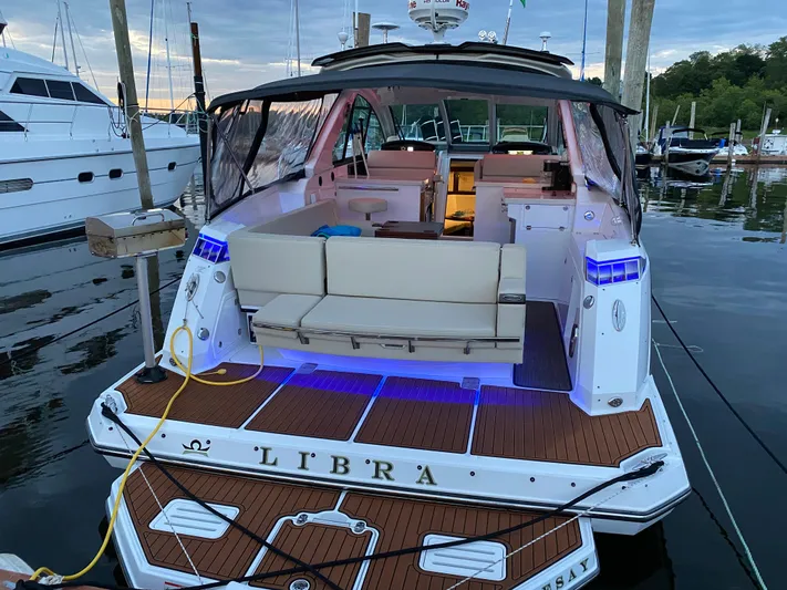 Libra Yacht Photos Pics 2016 Monterey 360 Sport Coupe docked, featuring illuminated deck and luxurious seating.