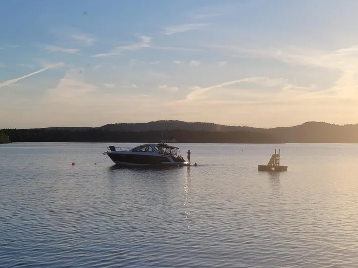 Libra Yacht Photos Pics 2016 Monterey 360 Sport Coupe on tranquil lake at sunset with distant hills.