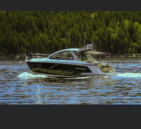Libra Yacht Photos Pics 2016 Monterey 360 Sport Coupe cruising on a serene lake with forested backdrop.