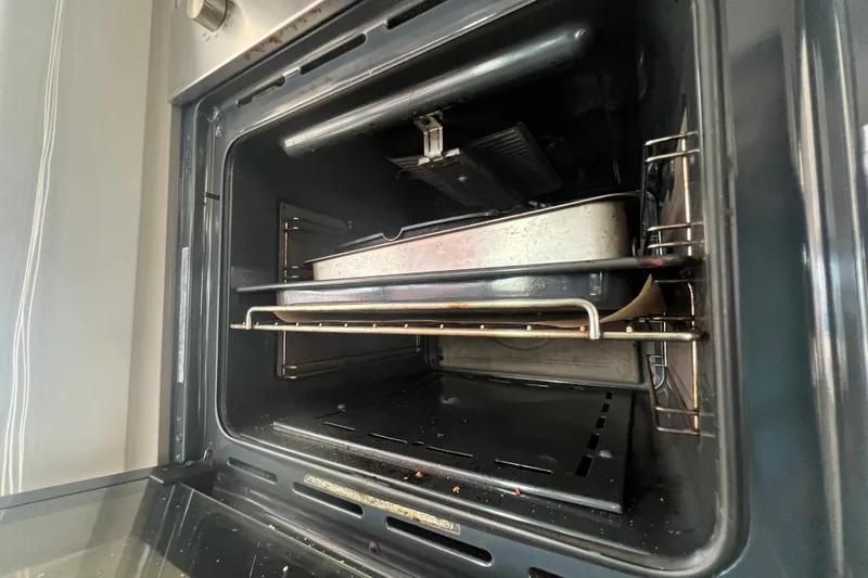 B&b Yachts Yacht Photos Pics Open oven with baking trays inside, showcasing a modern kitchen appliance.