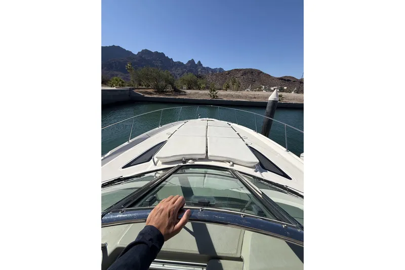  Yacht Photos Pics Person steering a 2011 Sea Ray 370 Sundancer boat in a scenic marina.