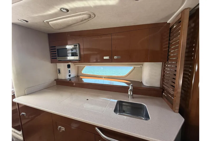  Yacht Photos Pics 2011 Sea Ray 370 Sundancer yacht kitchen with microwave, sink, and wooden cabinetry.