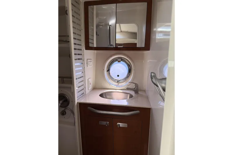  Yacht Photos Pics 2011 Sea Ray 370 Sundancer bathroom with sink, mirror, and porthole window.