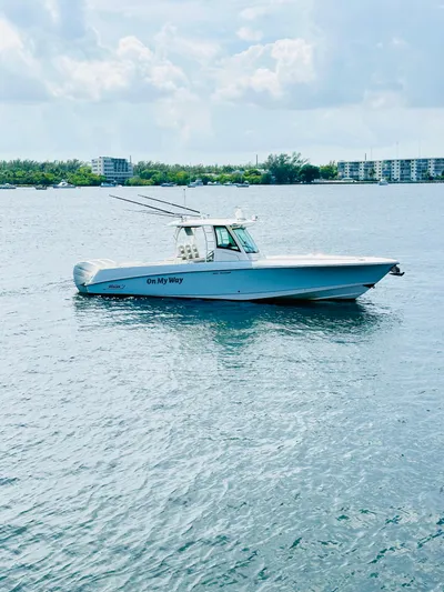  Yacht Photos Pics 2016 Boston Whaler 350 Outrage boat on calm water with buildings in the background.