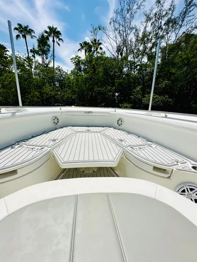  Yacht Photos Pics 2016 Boston Whaler 350 Outrage boat deck with lush greenery and palm trees in background.