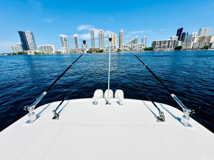  Yacht Photos Pics 2016 Boston Whaler 350 Outrage boat with fishing rods, city skyline in background.