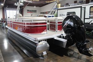 2025 Sun Tracker Party Barge 22 DLX pontoon boat with Mercury outboard motor in showroom.