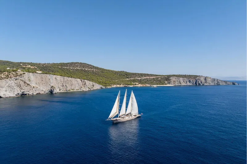 The Langley Yacht Photos Pics Aegean Yacht 3 Mast Schooner sailing near rocky coastline, 2009 model.