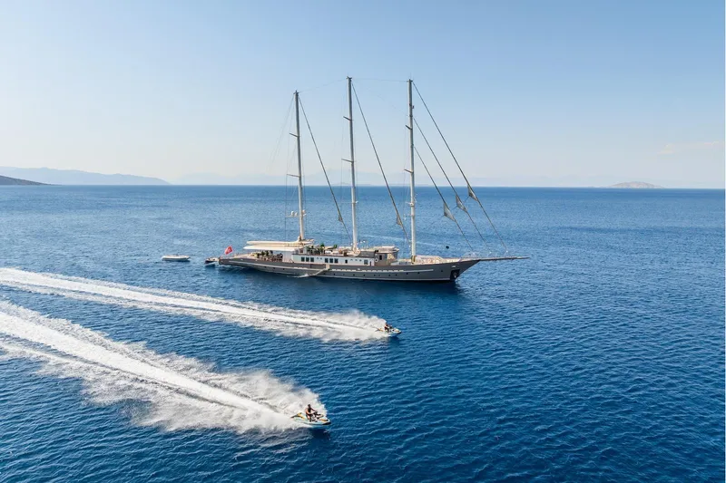 The Langley Yacht Photos Pics Aegean Yacht 3 Mast Schooner 2009 sailing with jet skis in open sea.