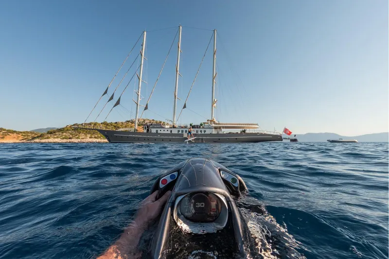 The Langley Yacht Photos Pics Aegean Yacht 3 Mast Schooner, 2009, sailing near rocky coastline, viewed from watercraft.