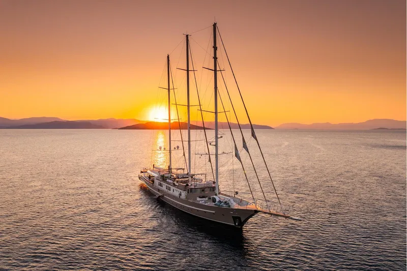 The Langley Yacht Photos Pics Aegean Yacht 3 Mast Schooner sailing at sunset, 2009 model, serene ocean view.