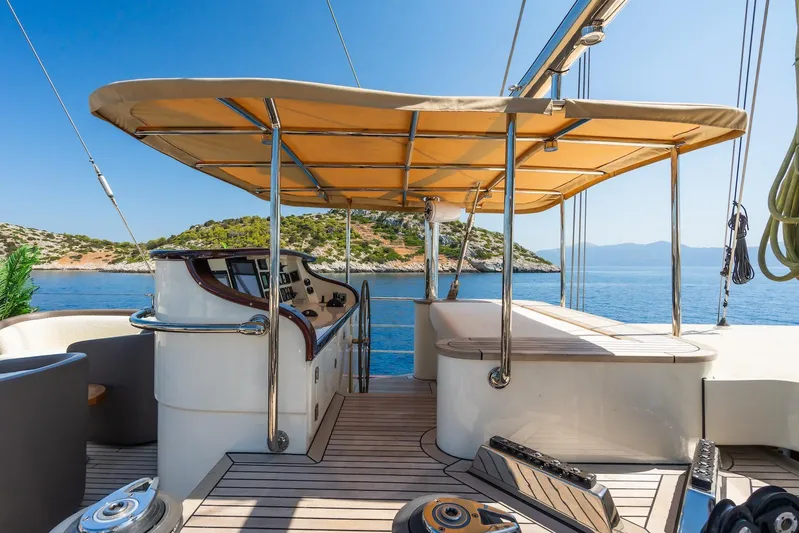 The Langley Yacht Photos Pics Aegean Yacht 3 Mast Schooner 2009, deck view with helm, canopy, and scenic ocean backdrop.
