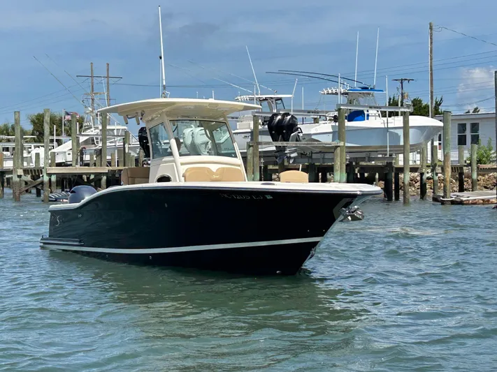  Yacht Photos Pics 2018 Scout 275 LXF boat on water near docks, clear sky background.