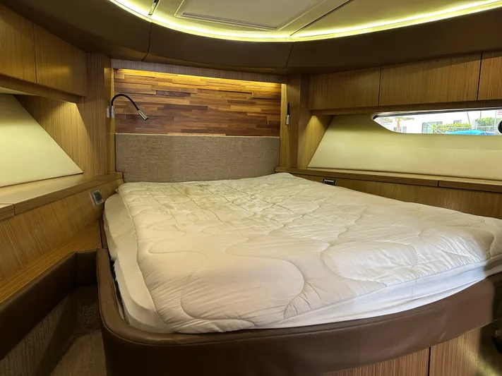  Yacht Photos Pics Luxurious cabin interior of 2016 Sea Ray L590 yacht with cozy bed and wooden accents.