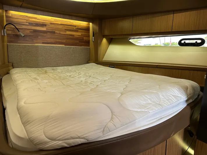  Yacht Photos Pics Luxurious cabin interior of 2016 Sea Ray L590 yacht with cozy bed and wooden accents.