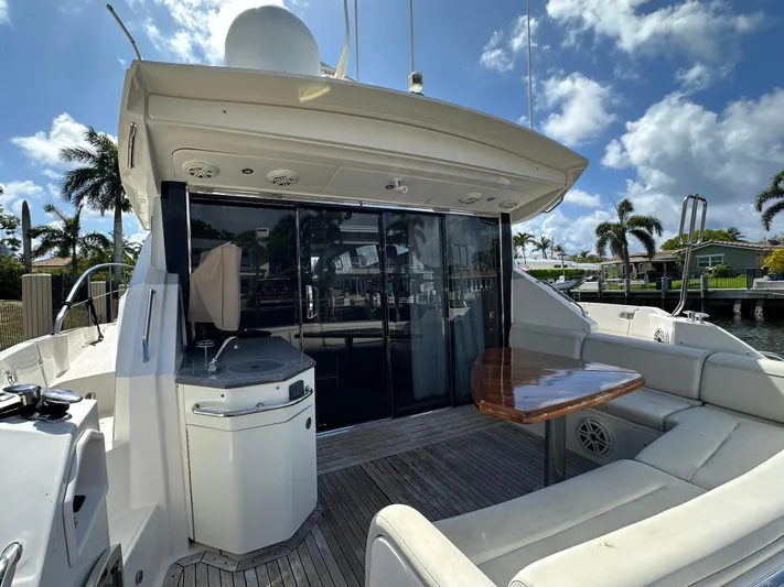  Yacht Photos Pics 2016 Sea Ray L590 yacht deck with seating, table, and outdoor kitchen under a sunny sky.