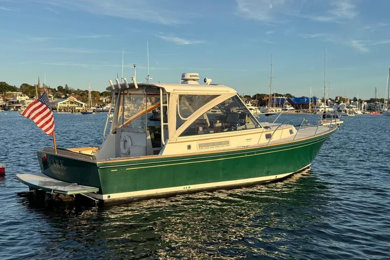 Lark Yacht Photos Pics 2000 Little Harbor Whisper Jet 34 boat on calm water, American flag displayed.