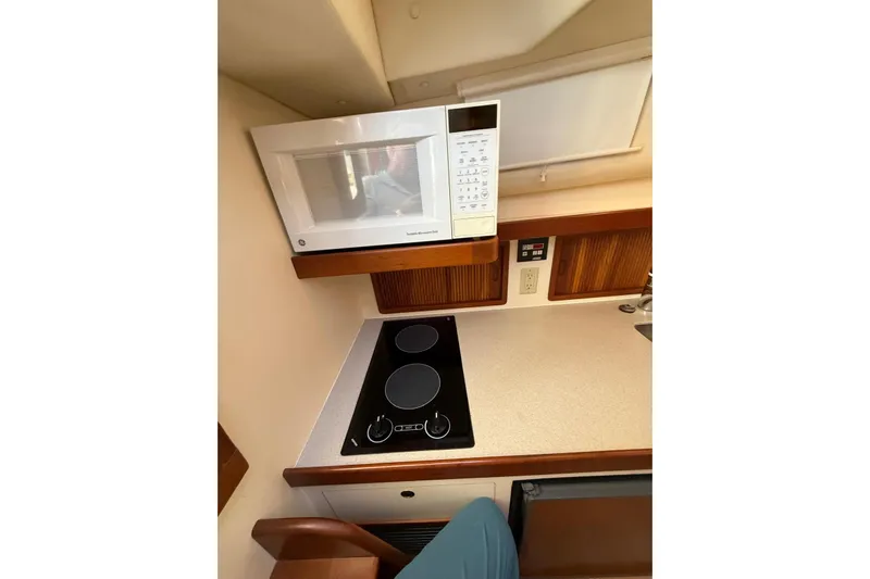Lark Yacht Photos Pics Compact kitchen area in a 2000 Little Harbor Whisper Jet 34 boat, featuring a microwave and stovetop.