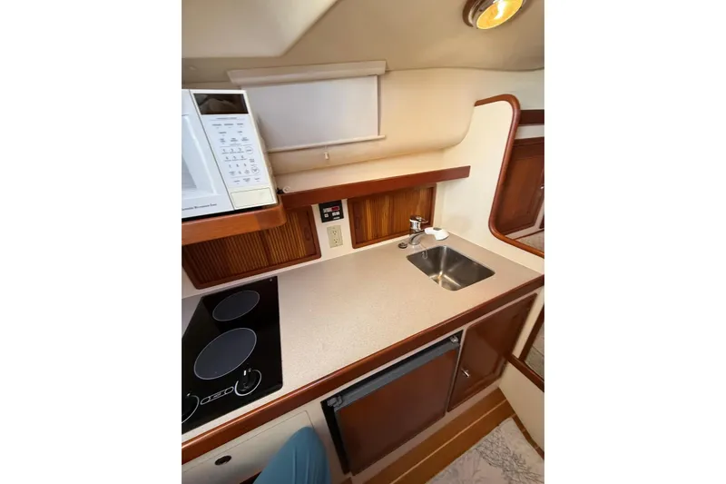 Lark Yacht Photos Pics Interior of 2000 Little Harbor Whisper Jet 34, featuring a compact kitchen with sink and stove.