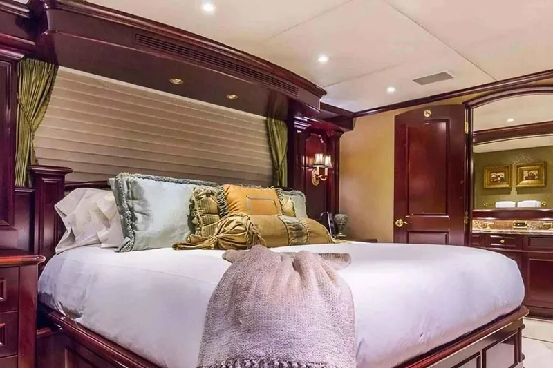 True Love Yacht Photos Pics Luxurious bedroom interior on 2003 Trinity Yachts Motoryacht, featuring elegant wood finishes and plush bedding.