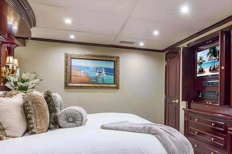 True Love Yacht Photos Pics Luxurious bedroom interior on 2003 Trinity Yachts motoryacht, featuring elegant decor and entertainment system.