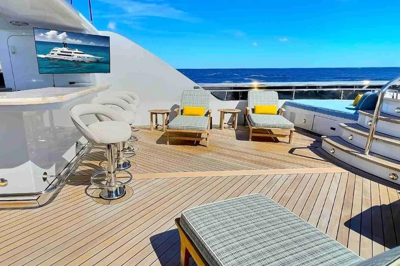 True Love Yacht Photos Pics Luxurious 2003 Trinity Yachts motoryacht deck with bar, lounge chairs, and ocean view.