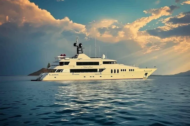 True Love Yacht Photos Pics Luxurious 2003 Trinity Yachts motoryacht cruising under a dramatic sky at sunset.