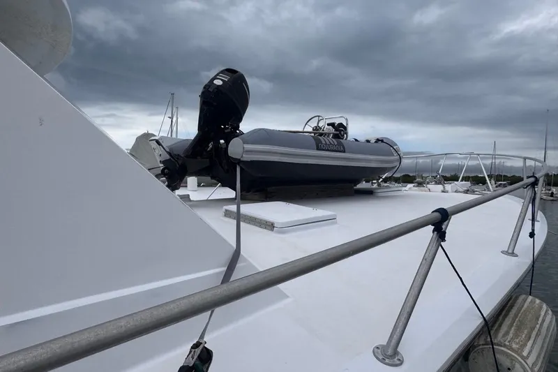  Yacht Photos Pics 1979 Hatteras 53 Motor Yacht deck with inflatable boat under cloudy sky.
