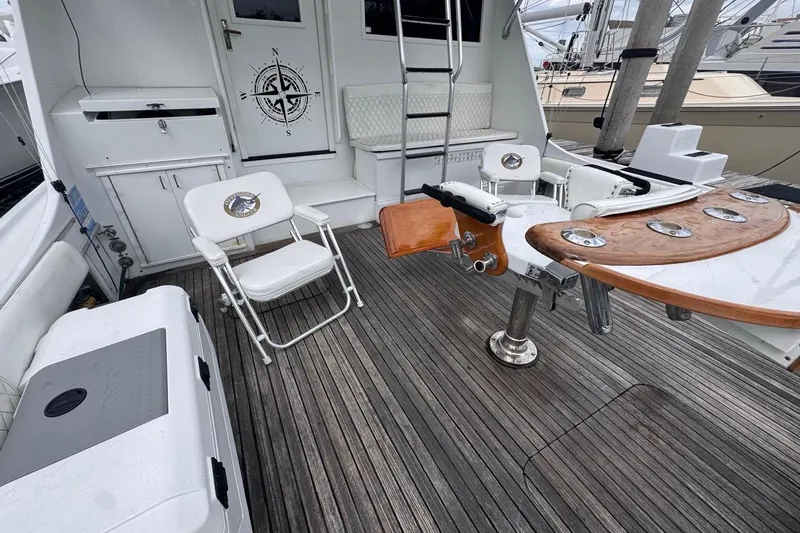  Yacht Photos Pics 1979 Hatteras 53 Motor Yacht deck with seating, fishing chair, and wooden table.
