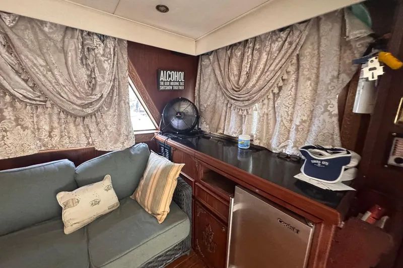  Yacht Photos Pics Interior of 1979 Hatteras 53 Motor Yacht with sofa, decorative curtains, and mini fridge.