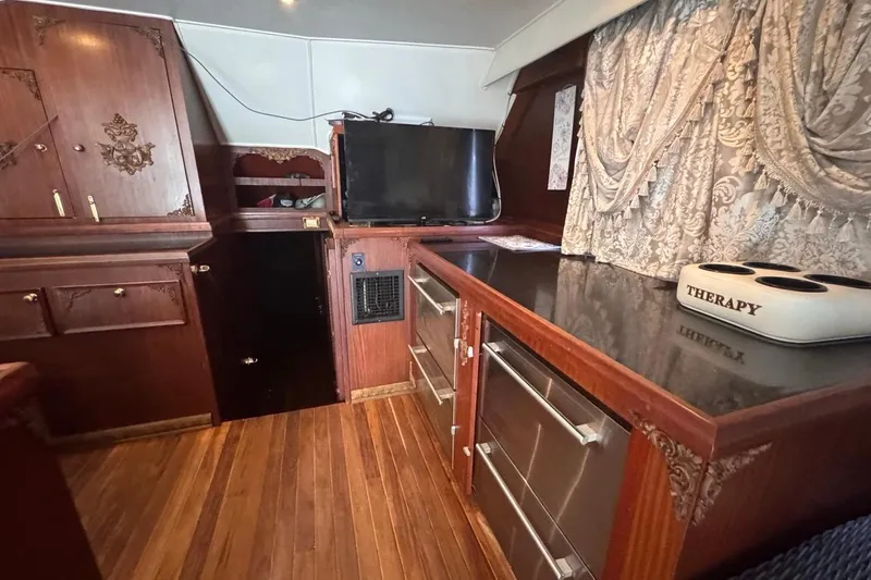  Yacht Photos Pics Interior of a 1979 Hatteras 53 Motor Yacht with wood cabinetry and elegant drapery.