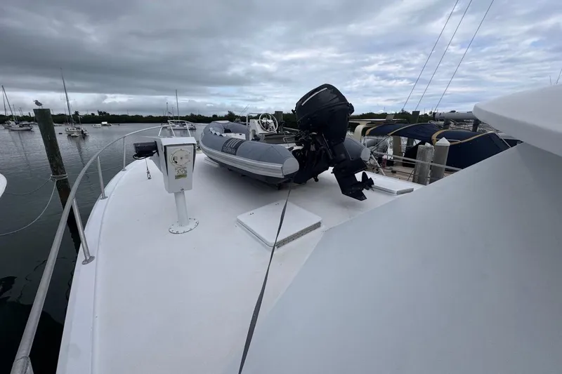 Yacht Photos Pics 1979 Hatteras 53 Motor Yacht with dinghy on deck, moored under cloudy skies.
