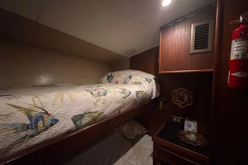  Yacht Photos Pics Cozy cabin interior of 1979 Hatteras 53 Motor Yacht with fish-themed bedding.