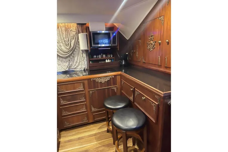  Yacht Photos Pics Luxurious wooden interior of a 1979 Hatteras Sportfish 53' yacht with ornate cabinetry.