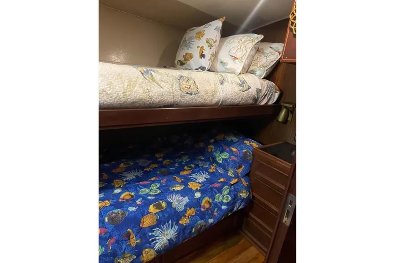  Yacht Photos Pics Bunk beds with marine-themed bedding in a 1979 Hatteras Sportfish 53' yacht cabin.