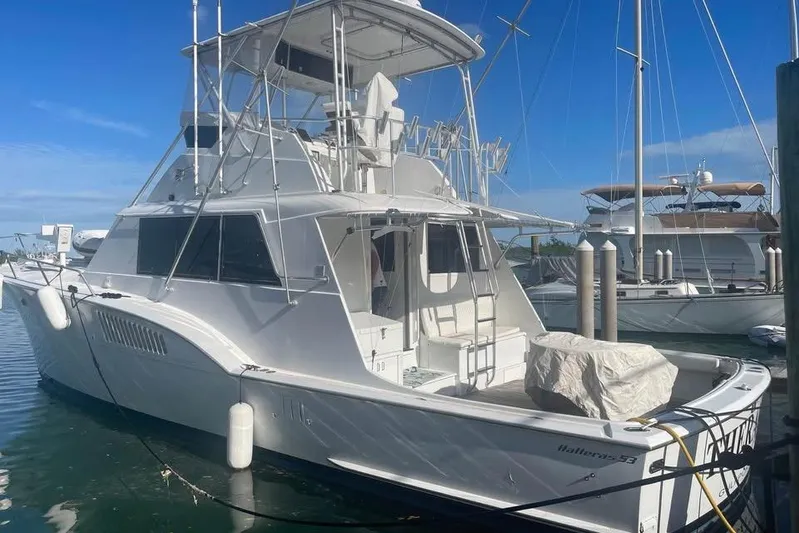  Yacht Photos Pics 1979 Hatteras Sportfish 53' yacht docked at marina under clear blue sky.