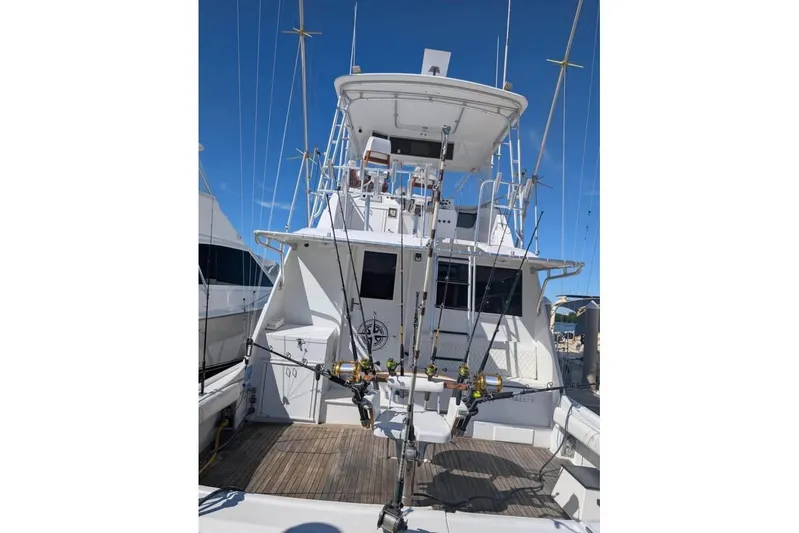  Yacht Photos Pics 1979 Hatteras Sportfish 53' yacht with fishing rods, docked under clear blue sky.