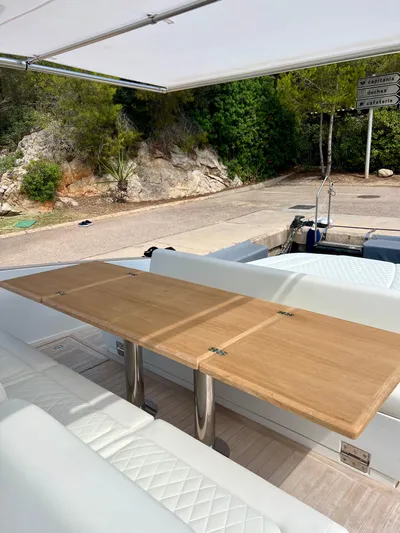  Yacht Photos Pics 2024 Solaris Power 44 Open yacht with elegant outdoor seating and wooden table.