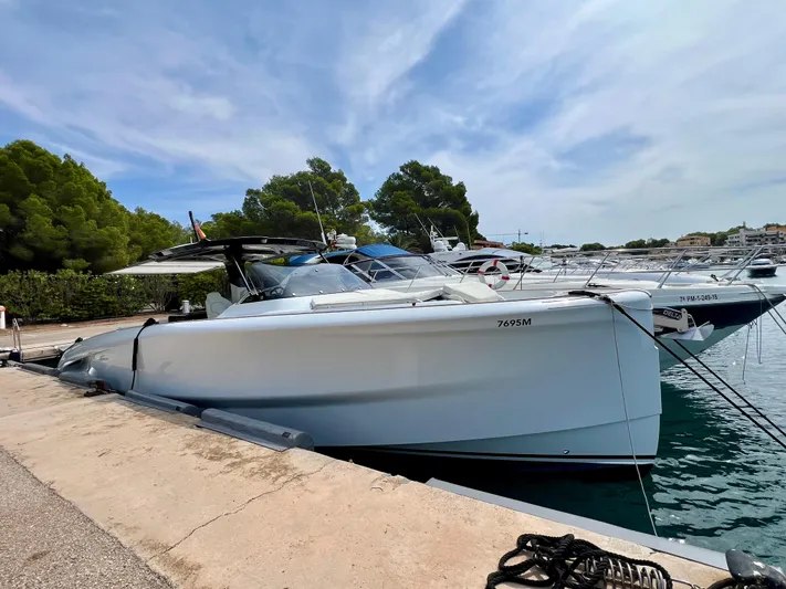  Yacht Photos Pics 2024 Solaris Power 44 Open yacht docked at a marina, surrounded by trees and clear skies.
