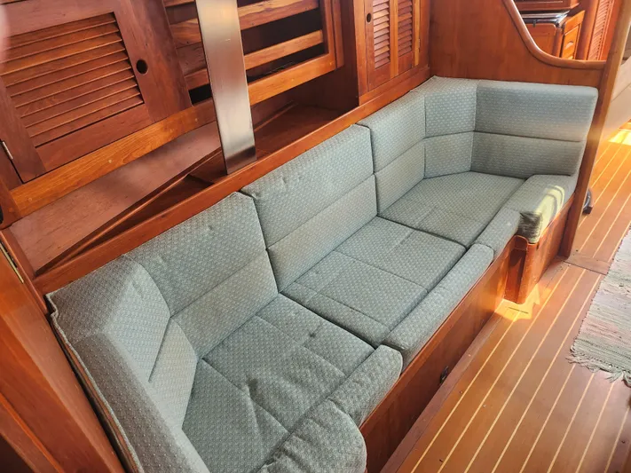 Sensation Yacht Photos Pics Interior of 1998 Tartan 4100 sailboat with cushioned seating and wooden cabinetry.