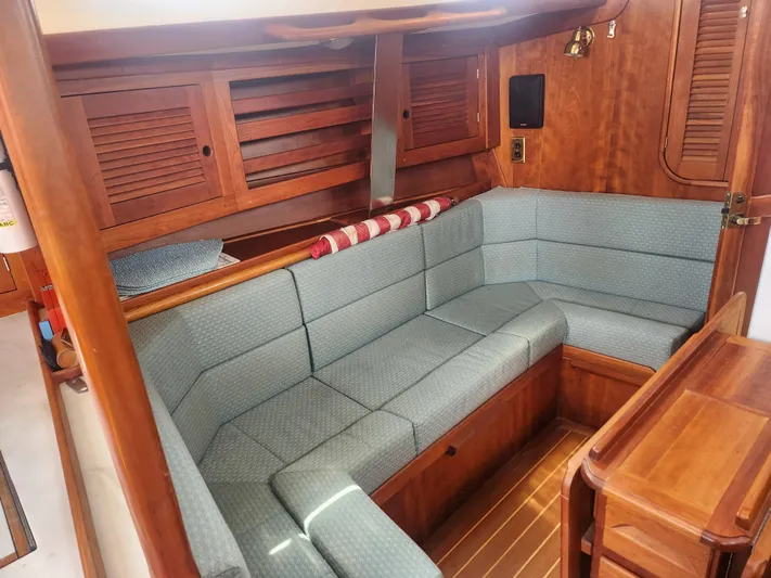 Sensation Yacht Photos Pics Interior of a 1998 Tartan 4100 sailboat with wooden cabinetry and blue cushioned seating.