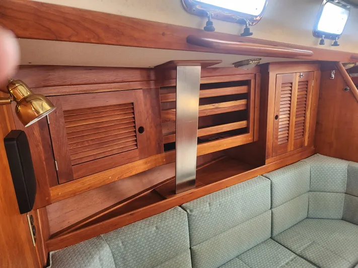 Sensation Yacht Photos Pics Interior of a 1998 Tartan 4100 sailboat with wooden cabinets and cushioned seating.